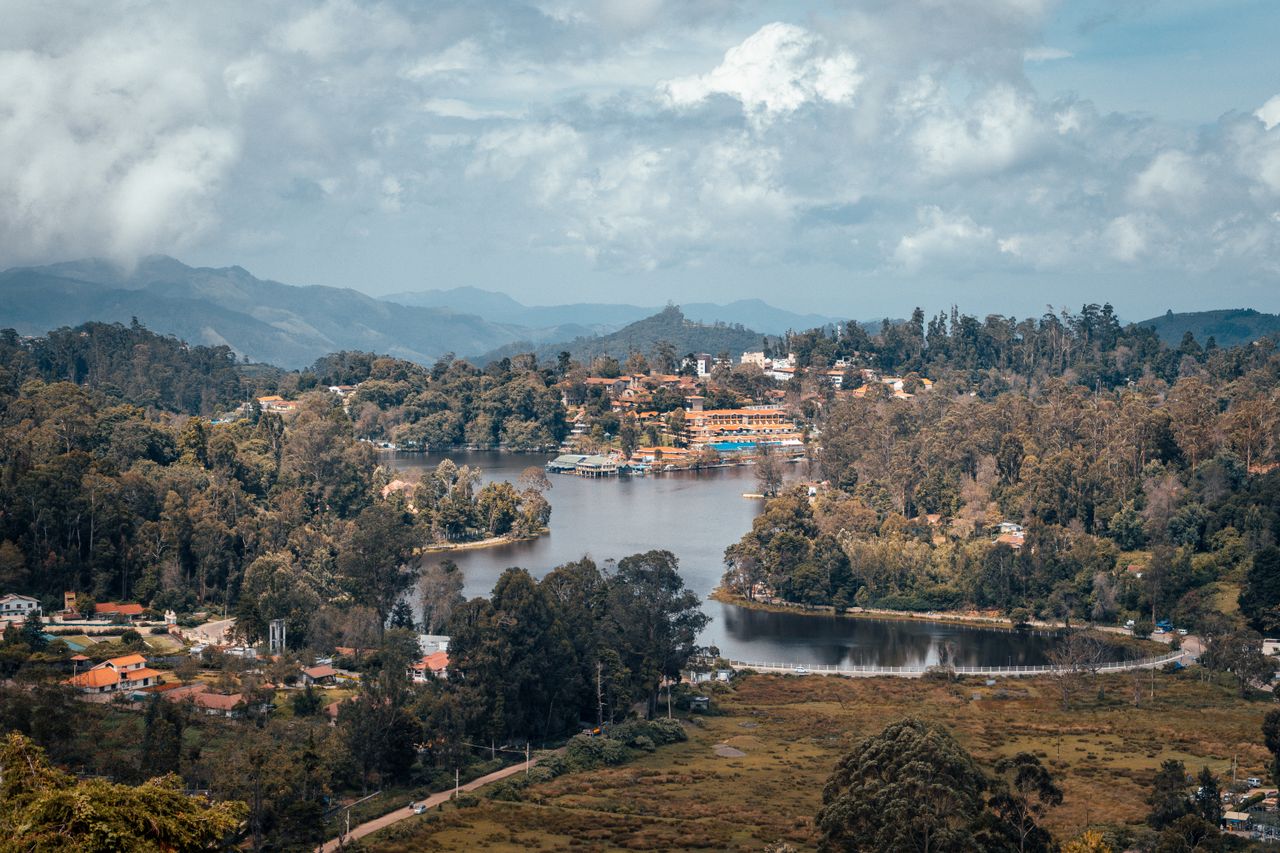 A beautiful aerial shot of Kodaikanal's lush landscape and serene lake surrounded by mountains.